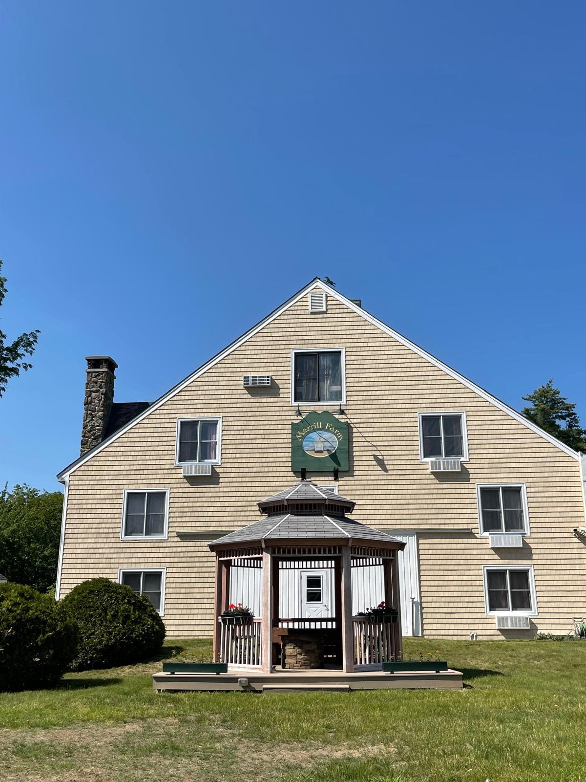 The barn gable and garden gazebo at Merrill Farm Inn under a blue summer sky