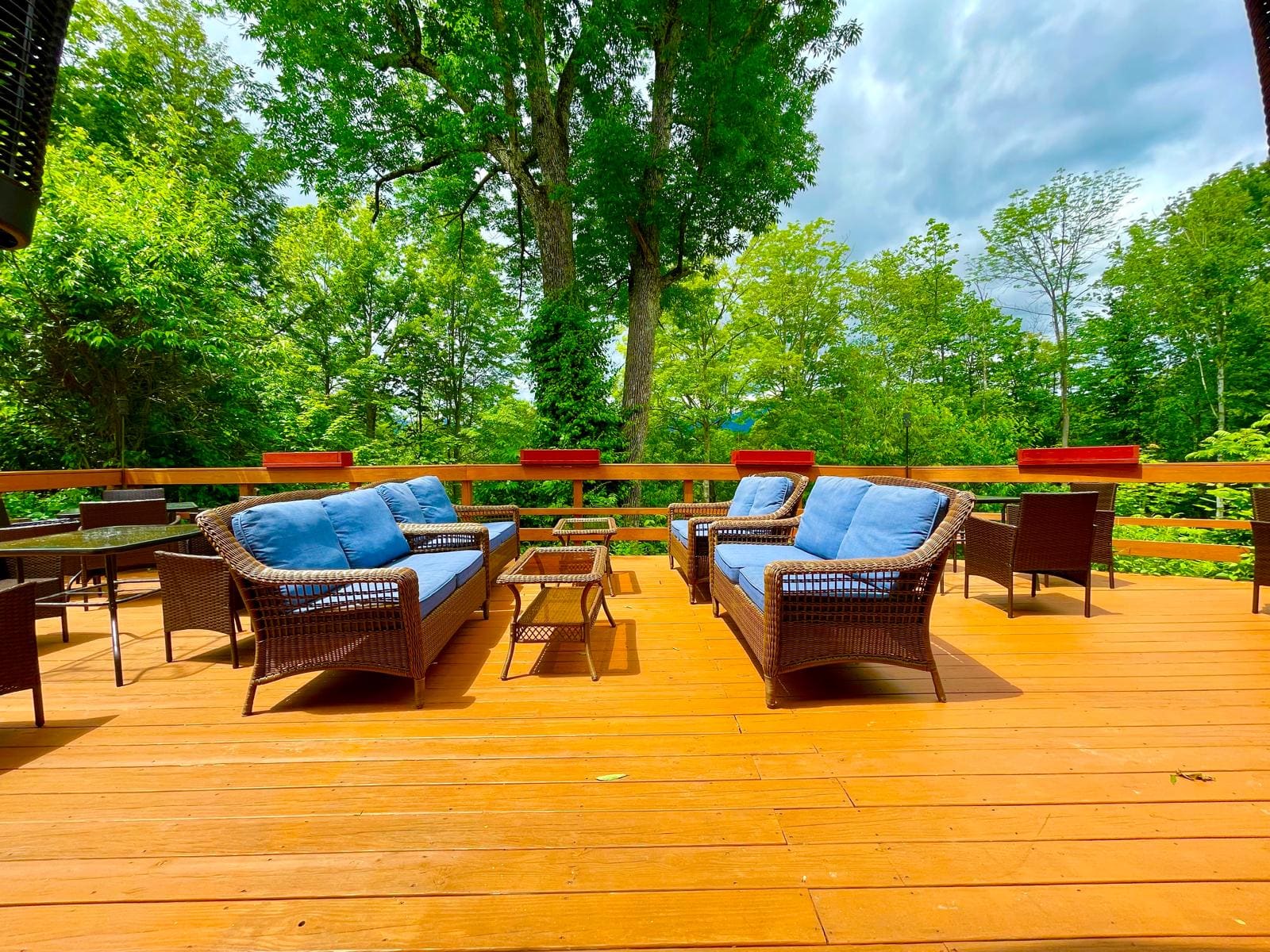 Wicker lounge sofas with blue cushions on the forest-side deck at Merrill Farm Inn